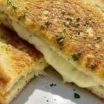 Garlic Bread Grilled Cheese sandwich sliced on white plate