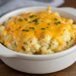 Crockpot Cheesy Potatoes with melted cheddar cheese and parsley garnish