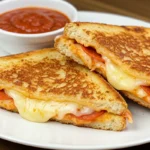 Pizza Grilled Cheese Sandwich sliced and served with marinara